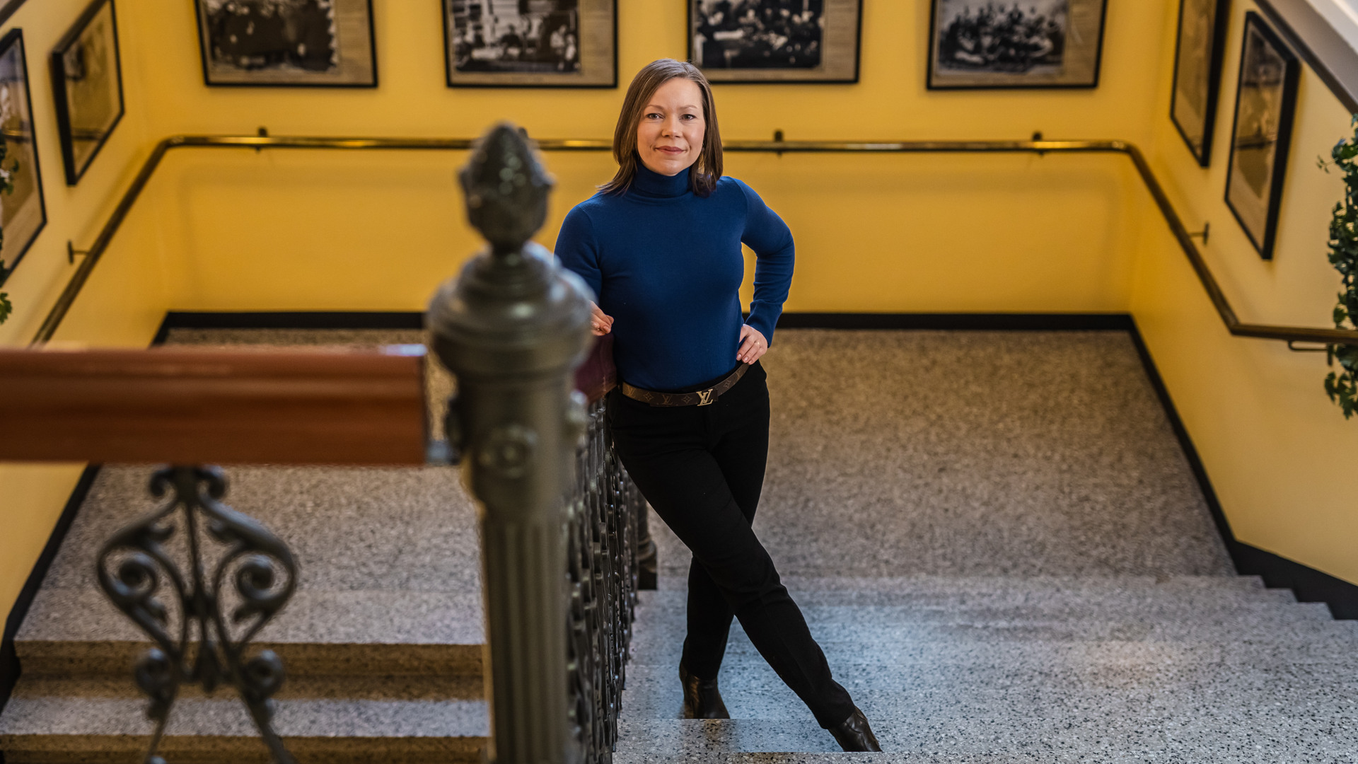 Pohjois-Savon maakuntajohtaja Tytti Määttä seisoo käytävässä, jonka seinillä on useita historiallisia kuvia.
